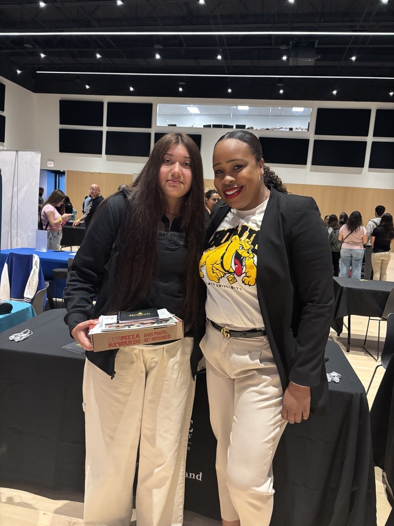 English: A Rich Township student poses with a college representative at the Chicago Latino College Expo while holding college materials and giveaways. Español: Una estudiante de Rich Township posa con una representante universitaria durante la Chicago Latino College Expo mientras sostiene materiales y obsequios universitarios.