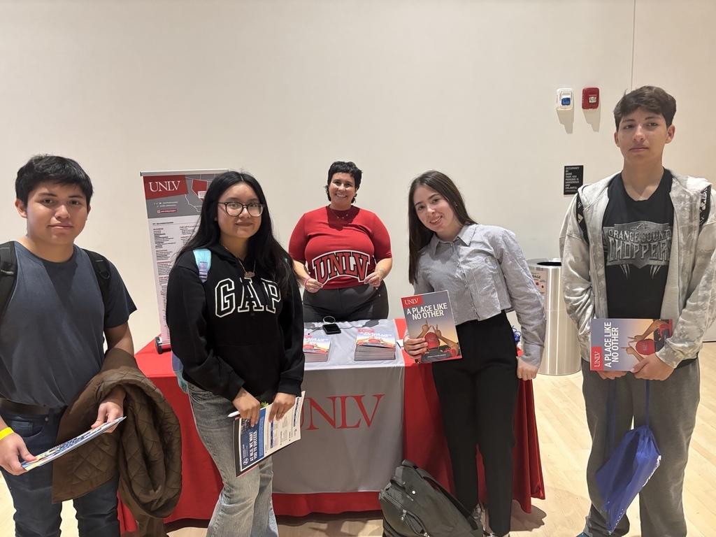 English: Three students visit the University of Nevada, Las Vegas information table during the college expo and speak with a university representative. Español: Tres estudiantes visitan la mesa informativa de la Universidad de Nevada, Las Vegas durante la feria universitaria y conversan con una representante de la universidad.