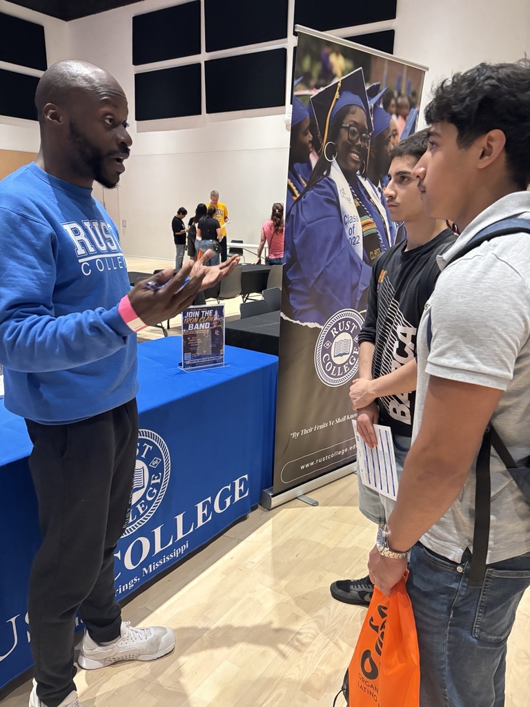 English: A Rust College representative speaks with two Rich Township students at the college expo while providing information about the college. Español: Un representante de Rust College conversa con dos estudiantes de Rich Township durante la feria y les brinda información sobre la universidad.
