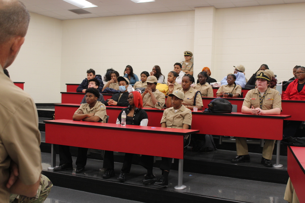 English: Graphic in Rich Township red, black, and white featuring military panelists seated beneath service flags. Text reads “Military Roundtable / Mesa Redonda Militar,” followed by “Students. Service. Conversation. / Estudiantes. Servicio. Diálogo.” and #RichInStudentSuccess.  Español: Gráfico en rojo, negro y blanco de Rich Township que muestra a miembros de un panel militar sentados frente a banderas. El texto dice “Military Roundtable / Mesa Redonda Militar”, seguido de “Students. Service. Conversation. / Estudiantes. Servicio. Diálogo.” y #RichInStudentSuccess.