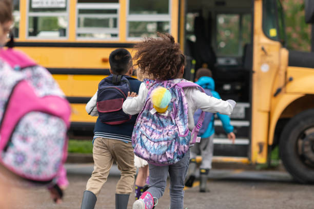 Kids running towards a school bus.