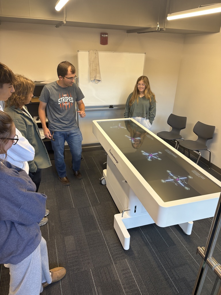 Mr. Pampe and a group of his chemistry students use the science table to further understand molecular geometry.