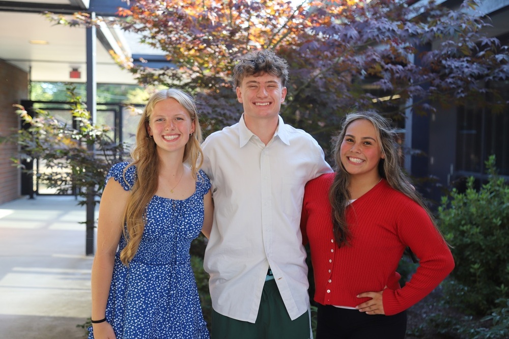 RHS students AJ Tretheway,  Henry Dudley, and Elizabeth Ibarra smiling and standing together in front of trees