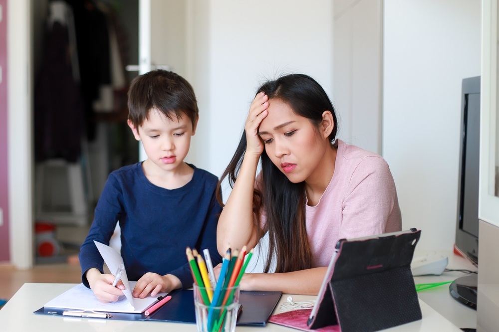 An overwhelmed mom struggles to help her son with his school work