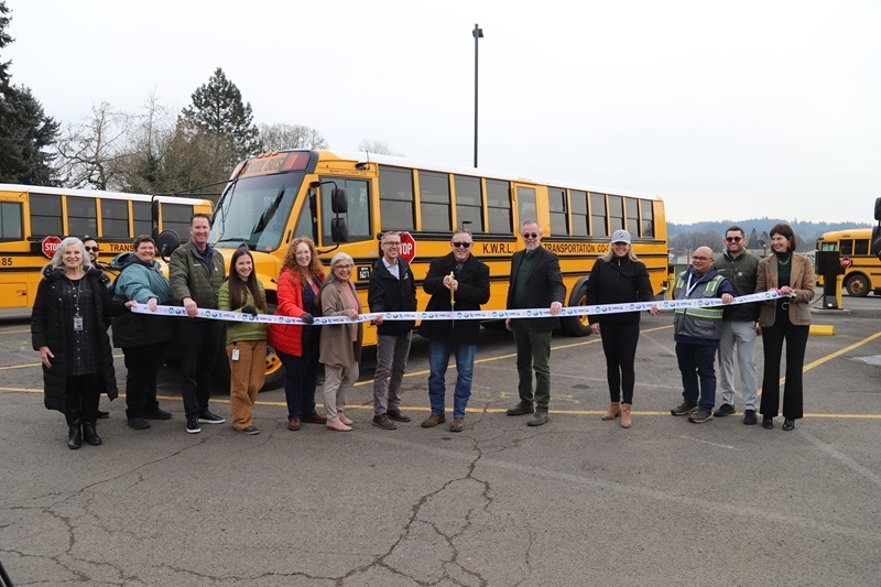 Representatives from KWRL Transportation and related school districts cut the ribbon on new fleet of electric buses