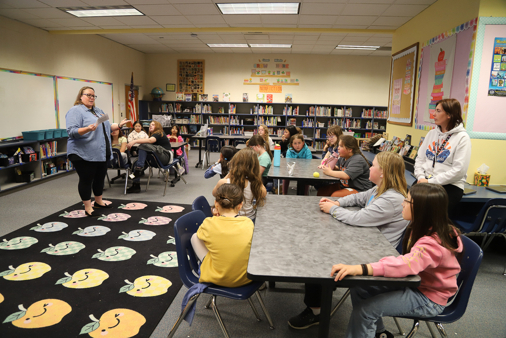 Val Striplin, Executive Director of the Oregon Public Health Association and School Counselor Anna Moskal look on as 4th graders in the nPower Girls after school club listen intently