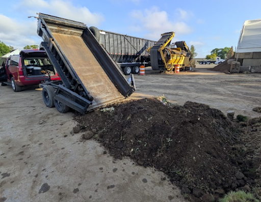 A flatbed truck dumps organic soil for use in the native plant garden