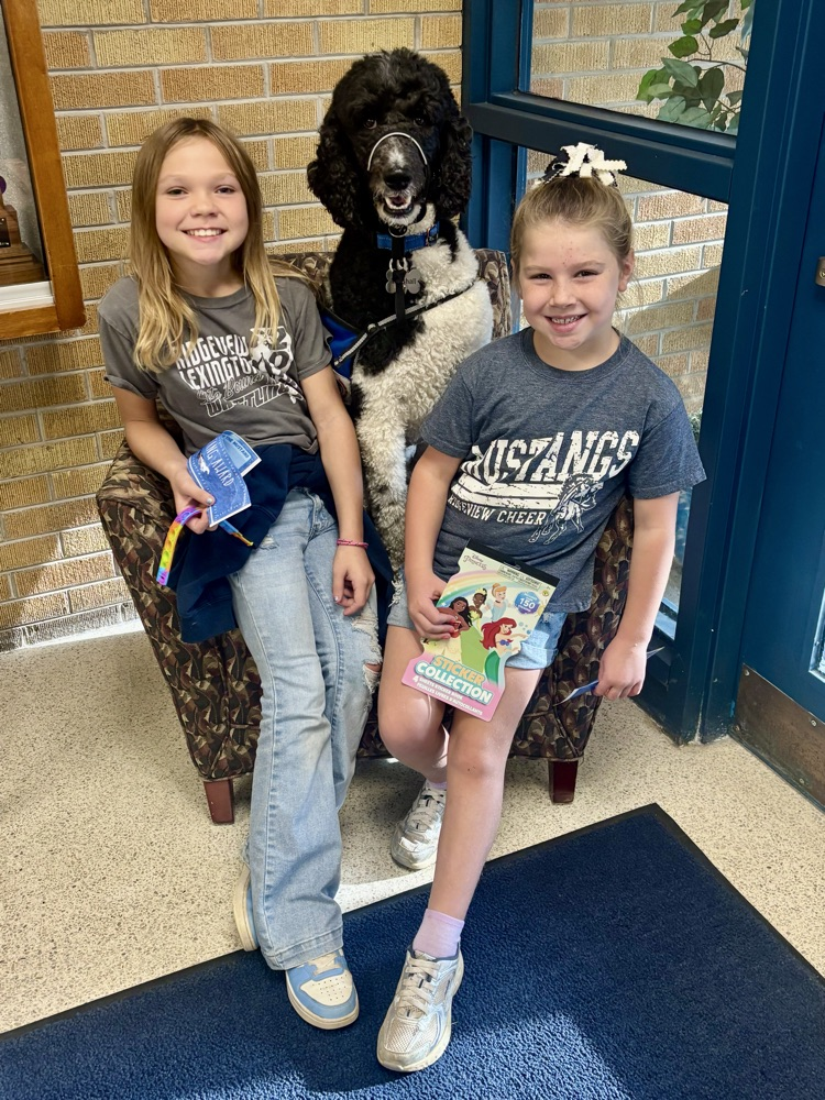 two prize winners sitting with dog