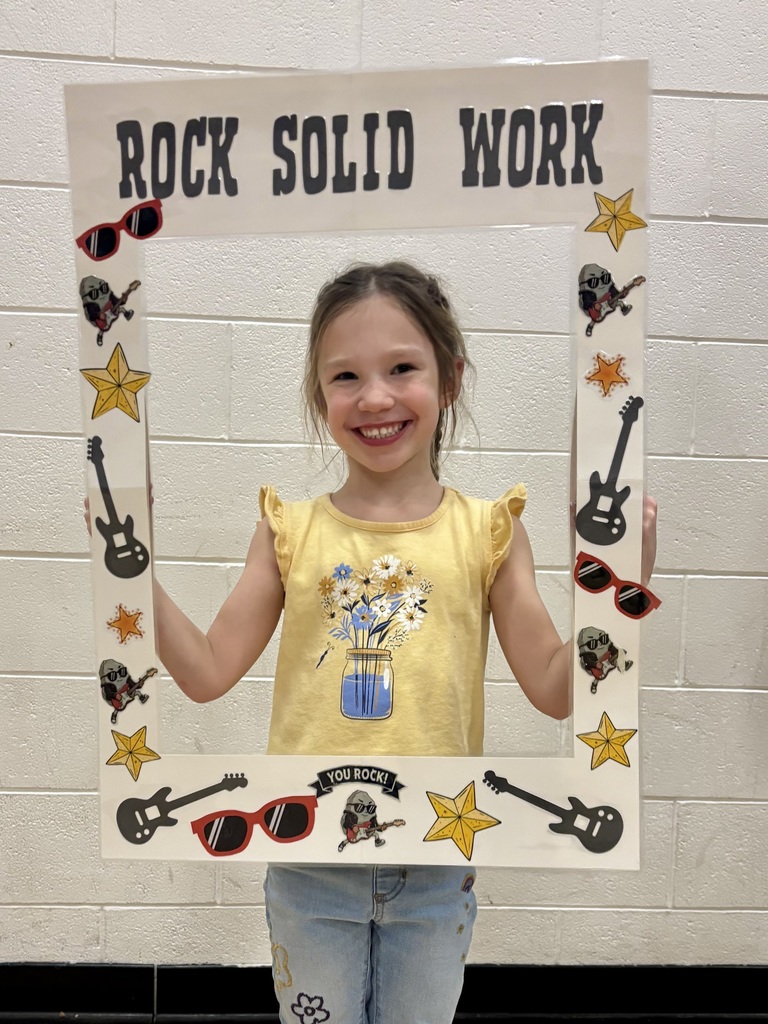 kindergarten student holding sign that says Rock Solid Work