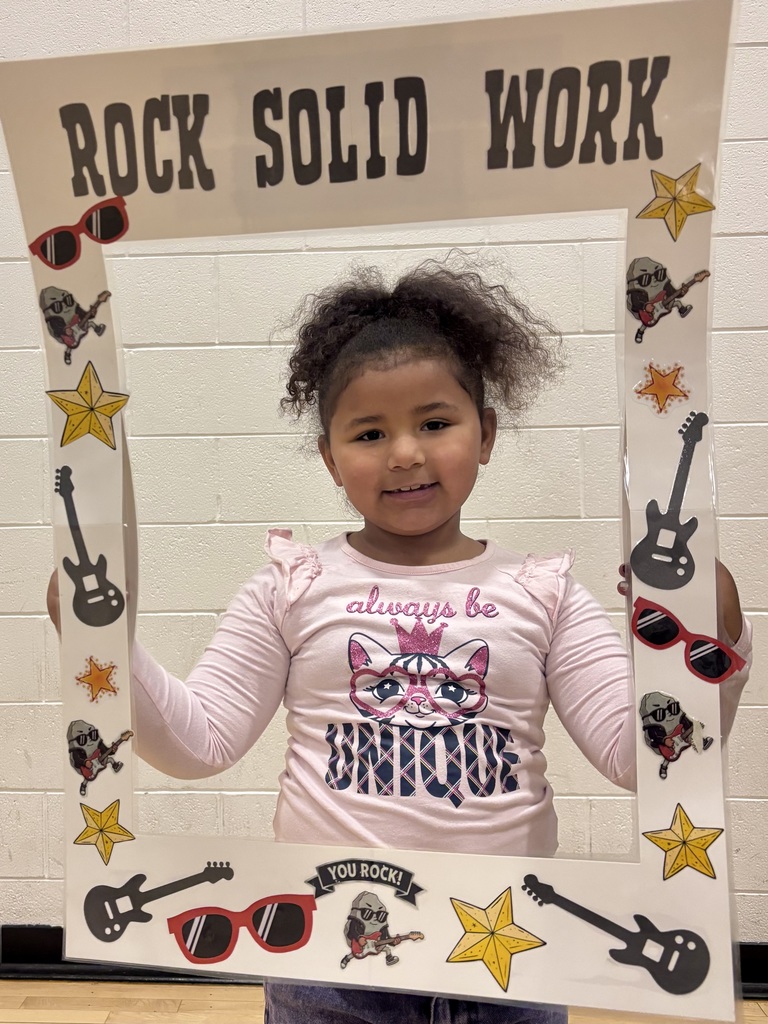 kindergarten student holding sign that says Rock Solid Work