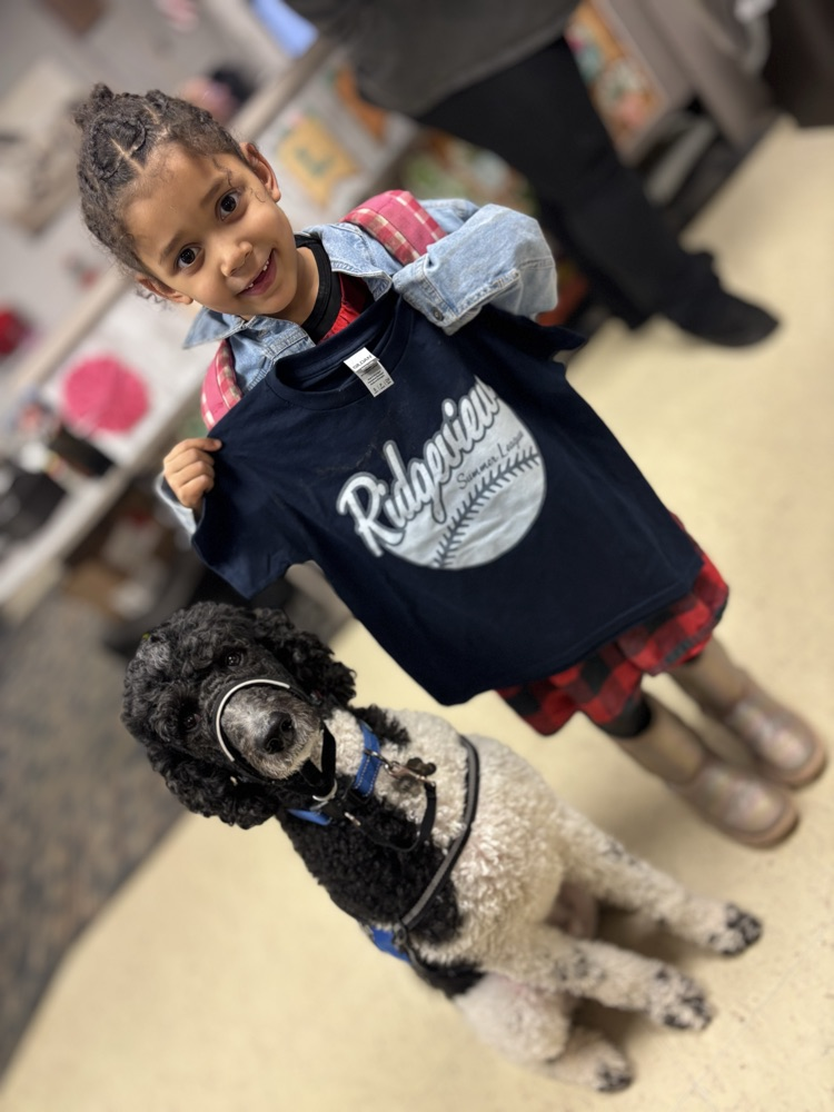 student with dog holding Tshirt 