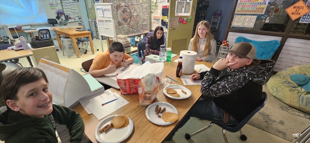 Students enjoying pancakes and sausage.