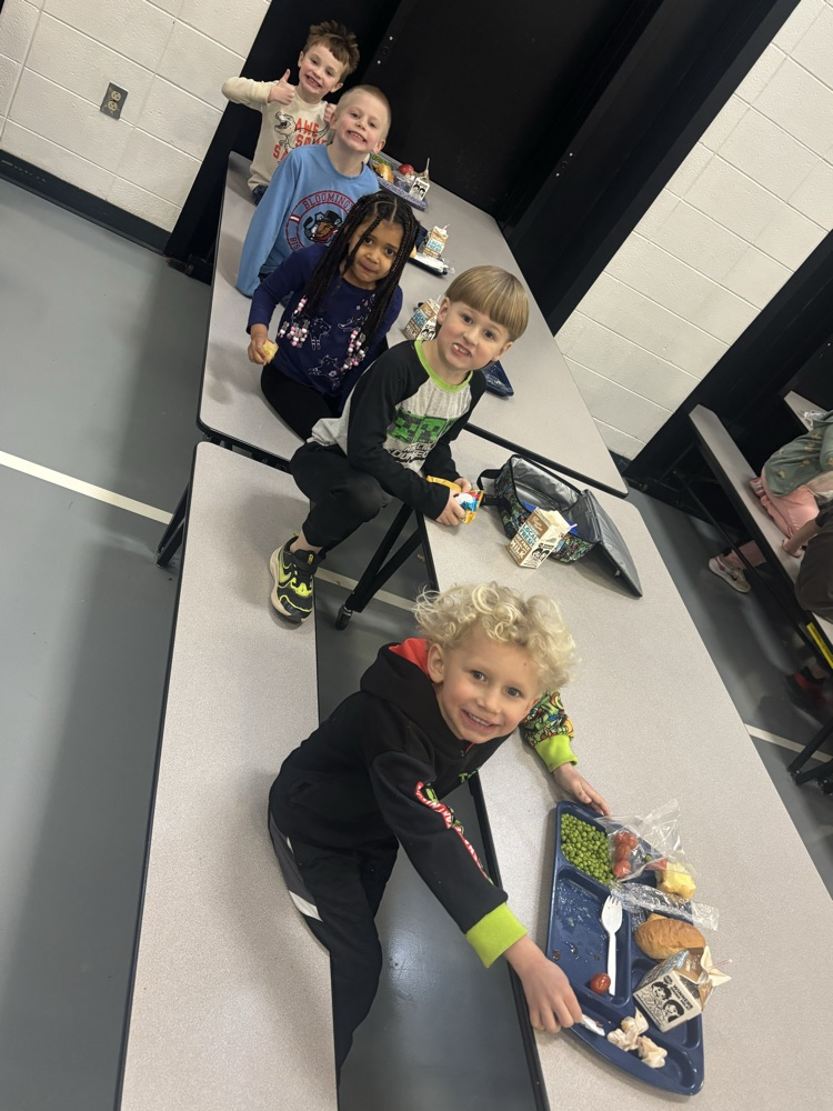 row of students smiling at their lunch table