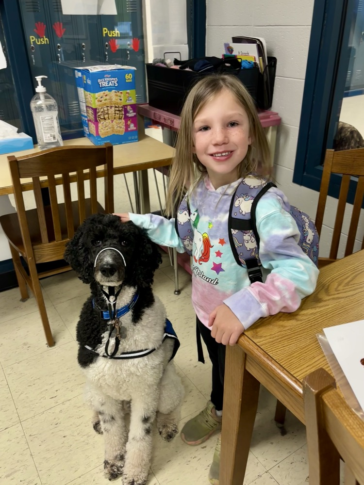 student smiling petting dog