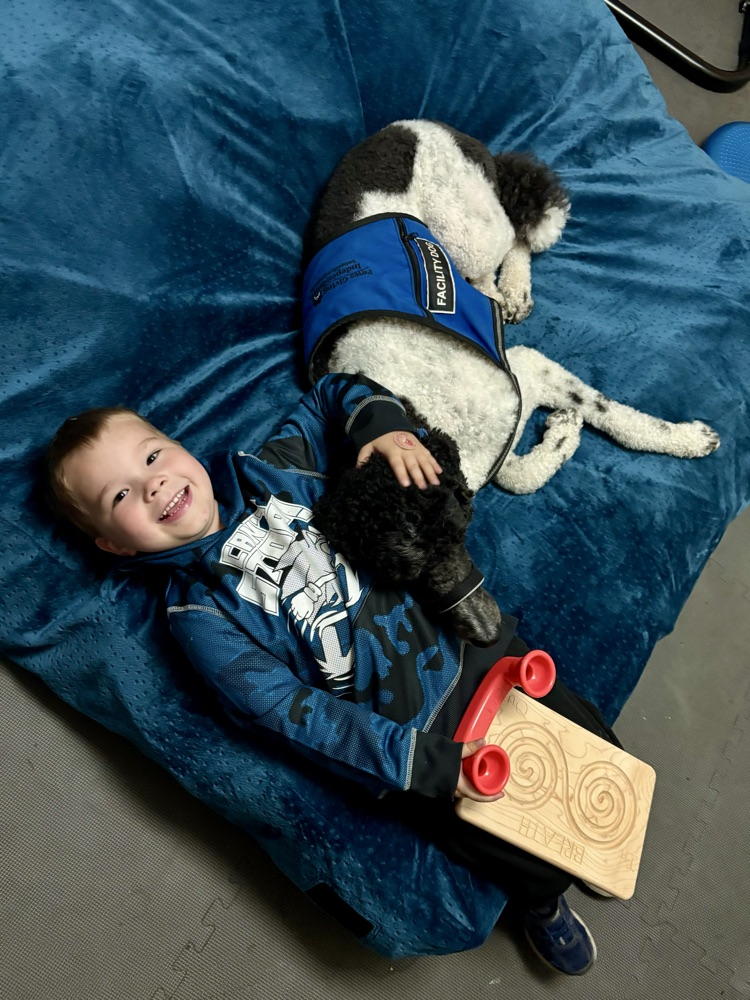 boy and dog snuggling