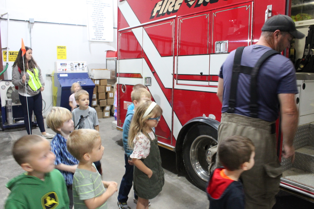 Preschoolers looking at fire trucks.