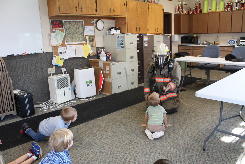 Preschoolers looking at firefighter