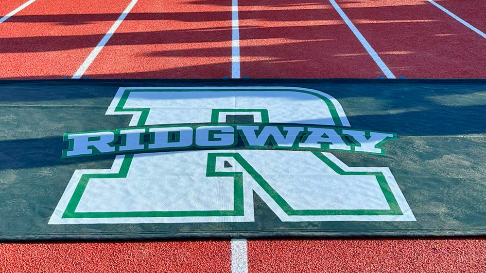 Ridgway logo on track mat placed across red running track lanes.