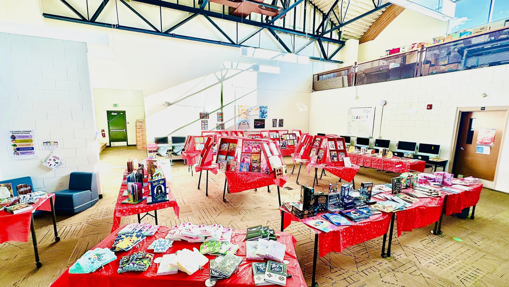 Scholastic Book Fair setup at RES with tables of colorful books and displays in a bright library space.
