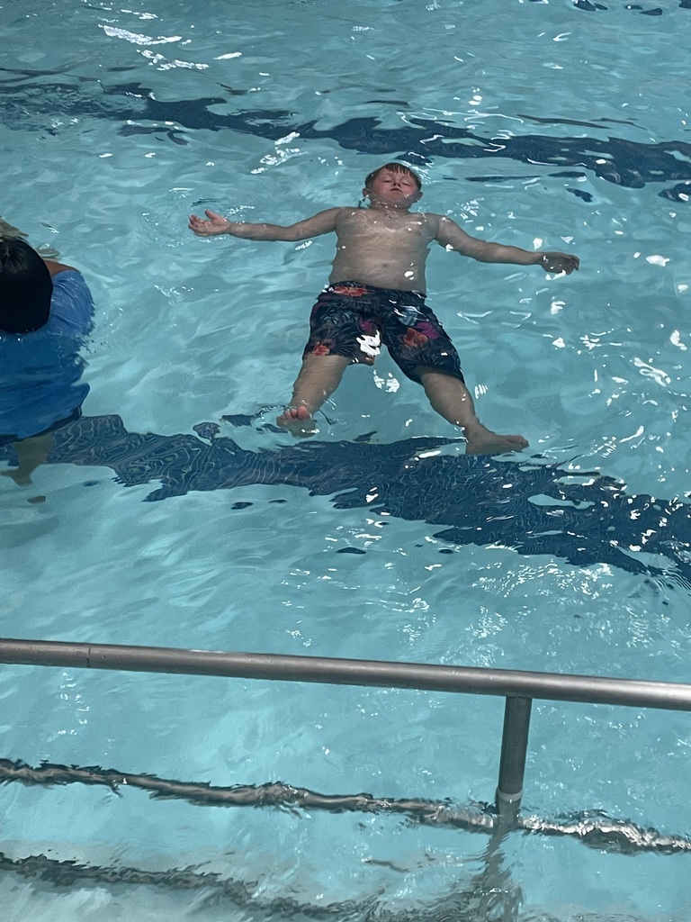 Student floating in the pool during Eagle U Swim