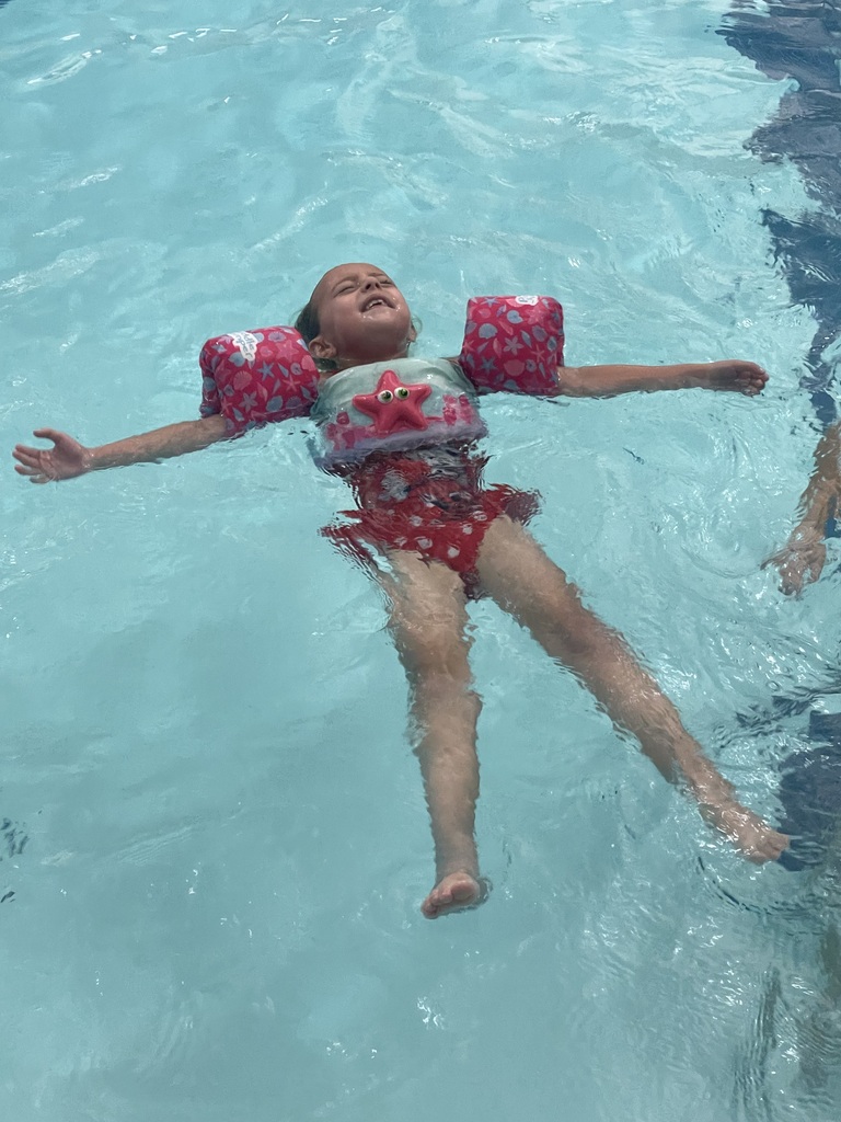 Student floating in the pool during Eagle U Swim