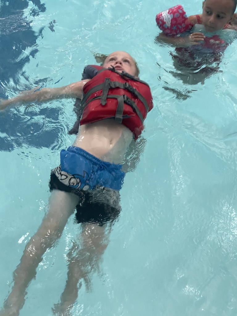 Student floating in the pool during Eagle U Swim