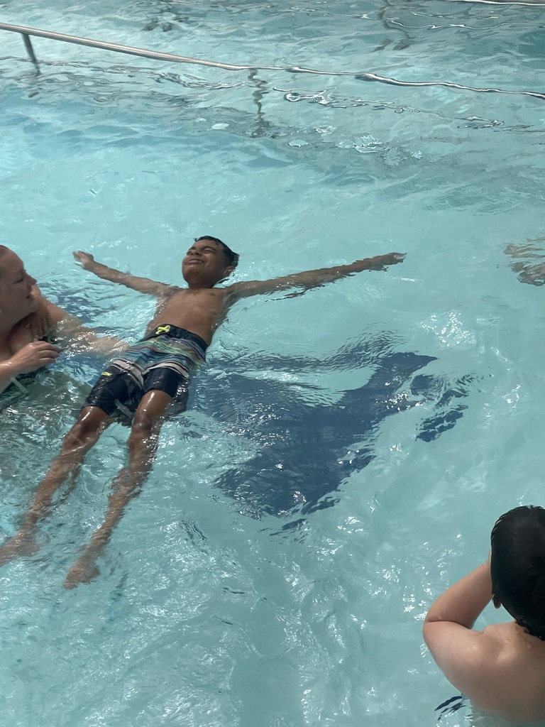 Student floating in the pool during Eagle U Swim
