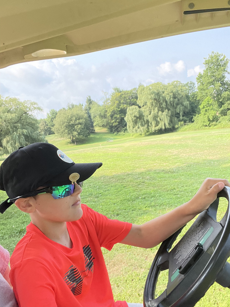 boy learning to drive golf cart