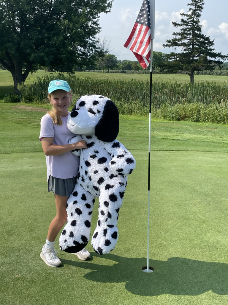 girl holding large dalmatian stuffed animal prize