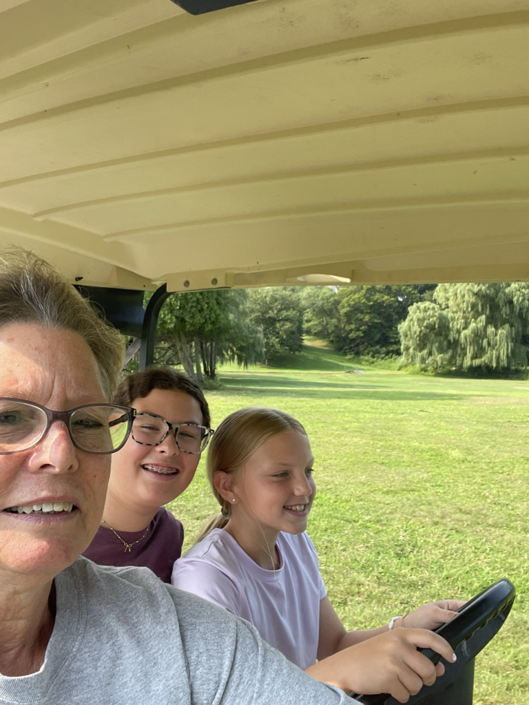 adult teaching girls to drive golf cart 