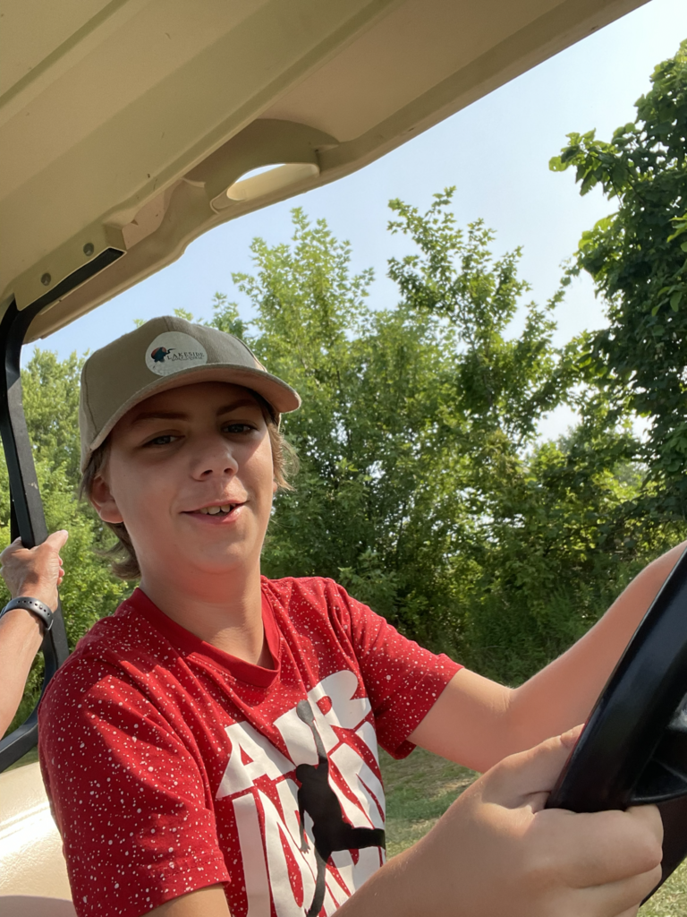 young man learning to drive golf cart