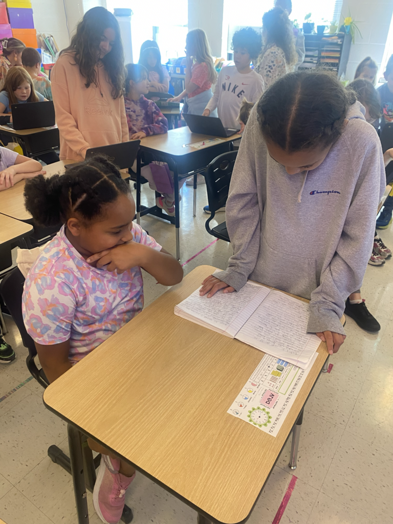 Two young children working together on a laptop.