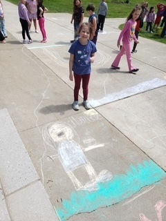Students  outside drawing kind messages - Better World Day 