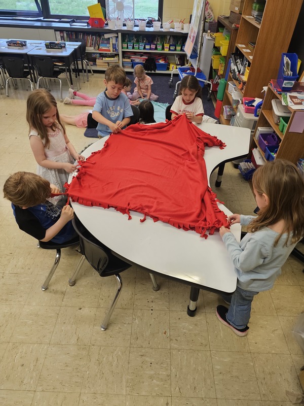 Kindergarten students making blankets for the animals in the shelters. 