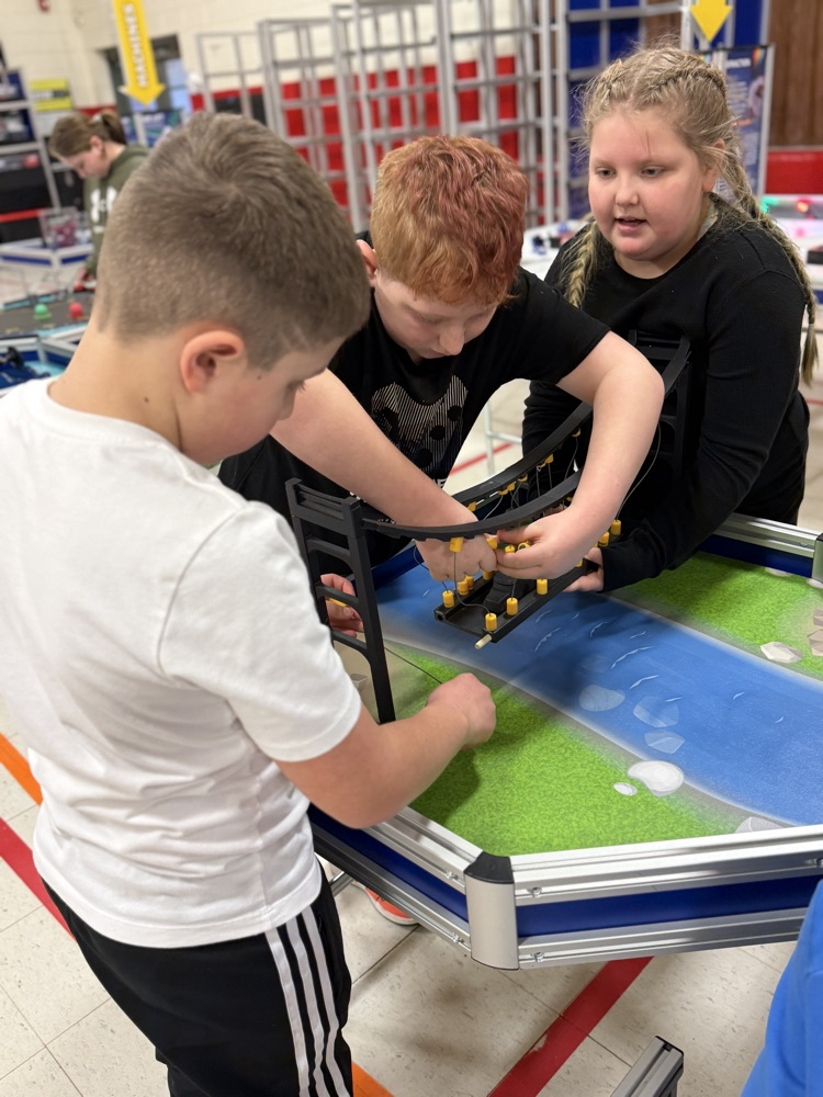 students enjoying the mobile units provided by the clay center. they are working to build a suspension bridge. 