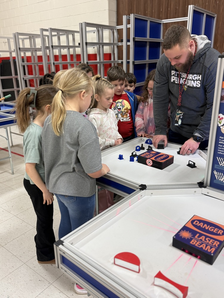 students working at the laser table of the clay 2 go unit 
