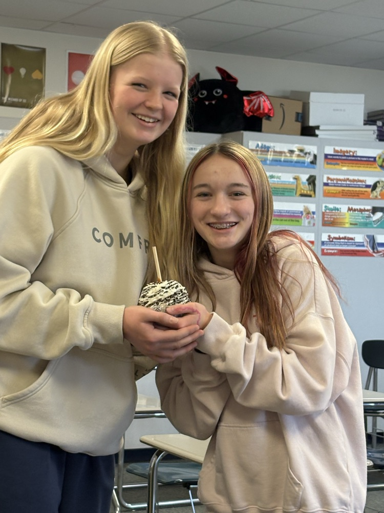 8th graders holding a candy apple.