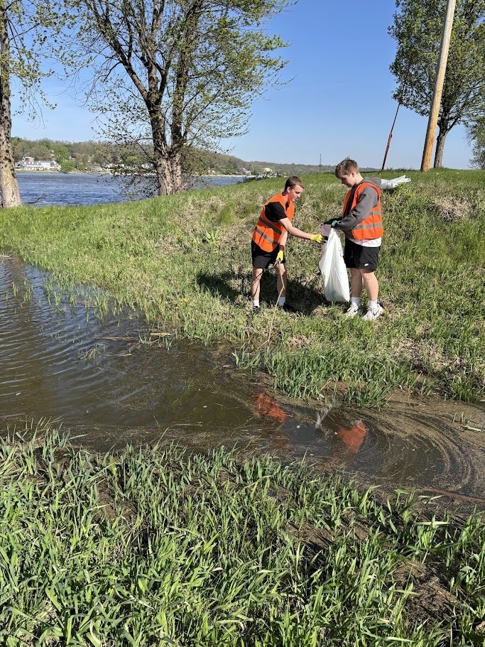 two students cleaning near a puddle