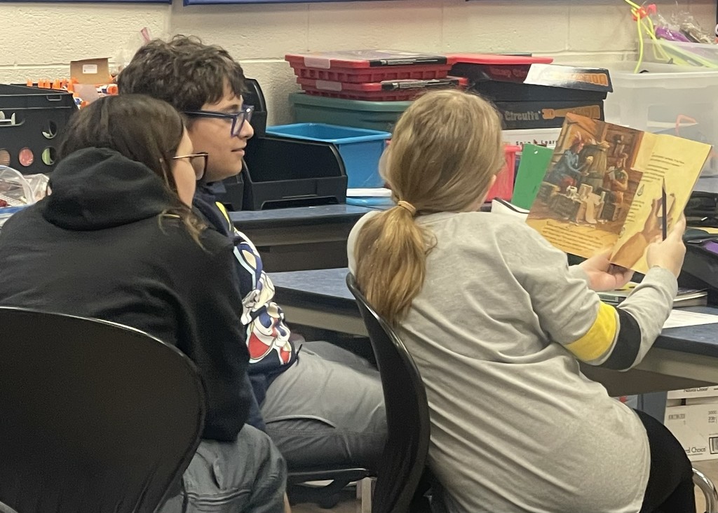 Trio of students reading math adventure books