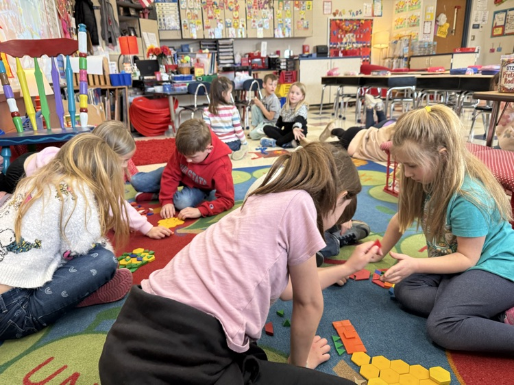 students working with partners with shapes