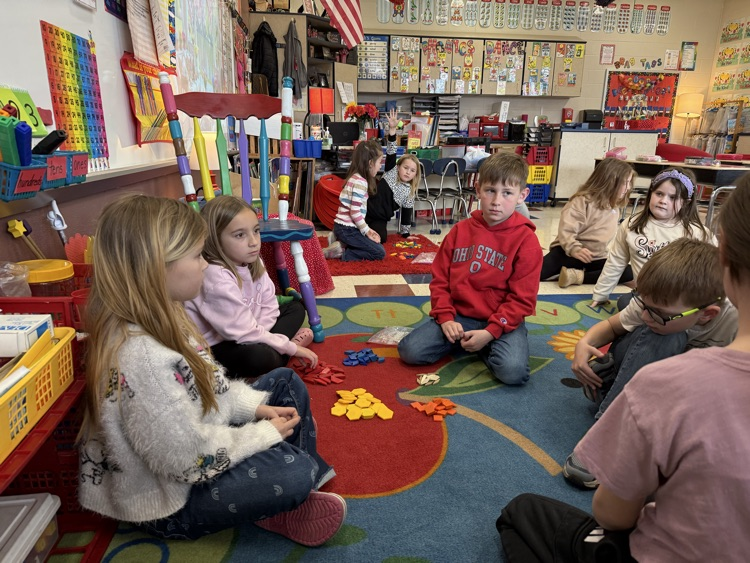 Working together in small groups to sort shapes