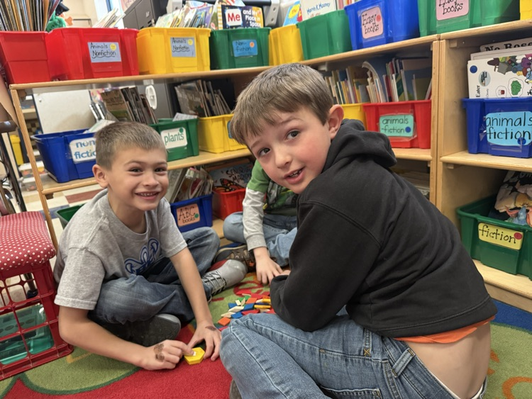 two boys working with shapes 