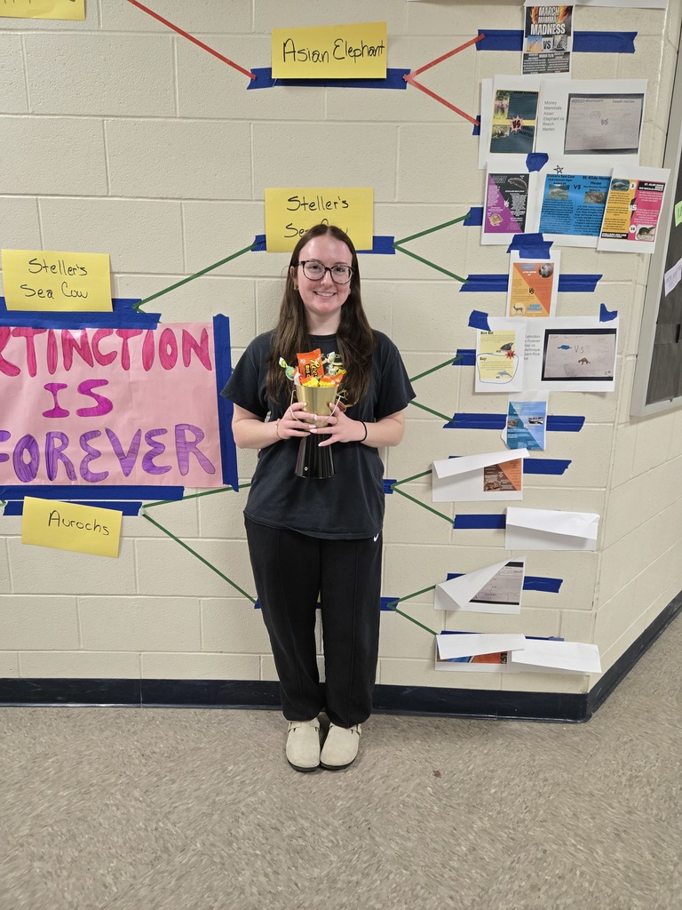 Winner Kohlie with trophy in front of bracket wall