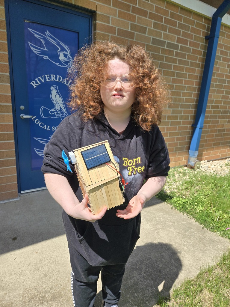Student holding house up to the sun. 