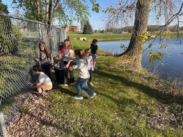 picking up trash along the fence