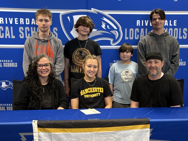 Lillian signing with parents and siblings 