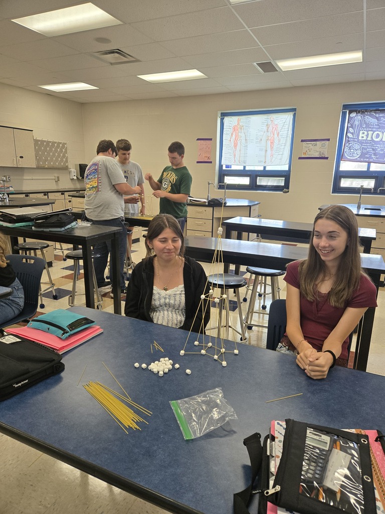 group of girls showing off their spaghetti noodle tower