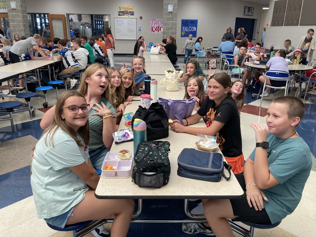 Image includes students during their lunch period smiling bit for the First day of school