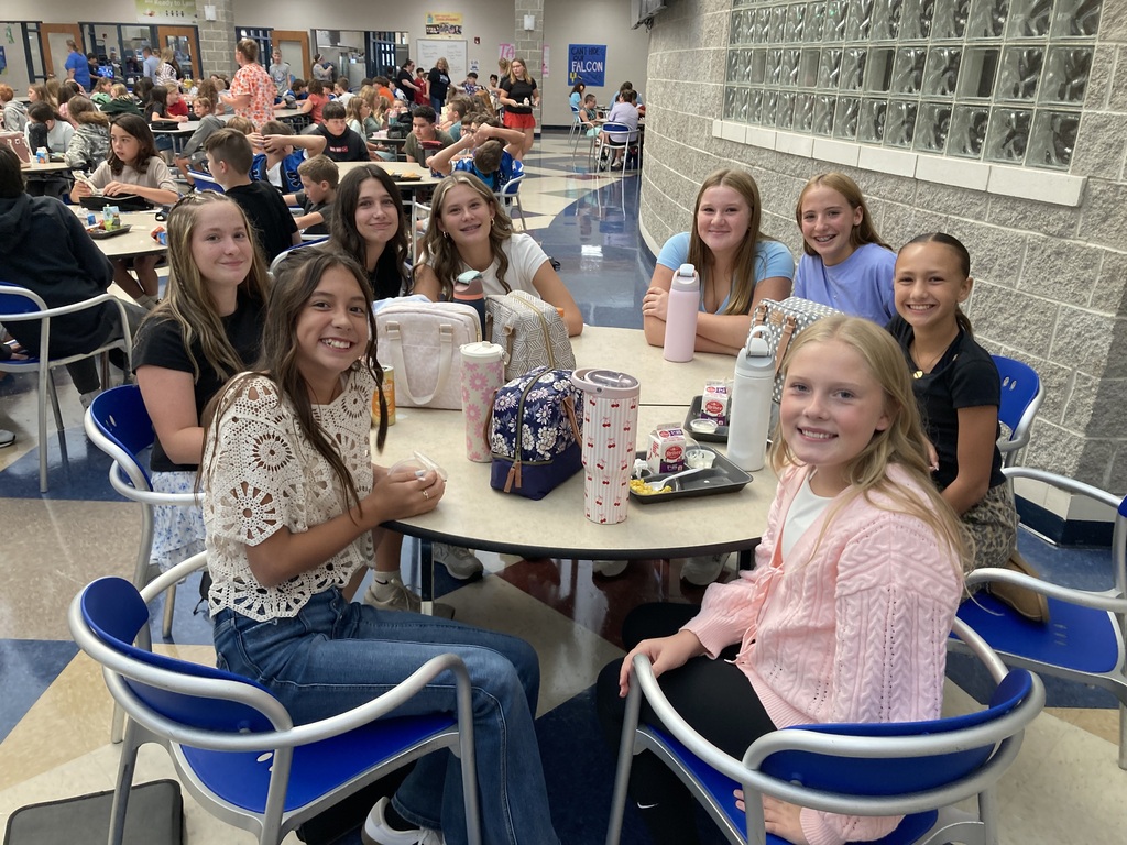 Image includes students during their lunch period smiling bit for the First day of school