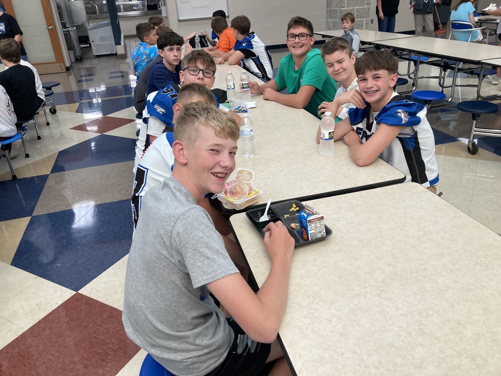 Image includes students during their lunch period smiling bit for the First day of school